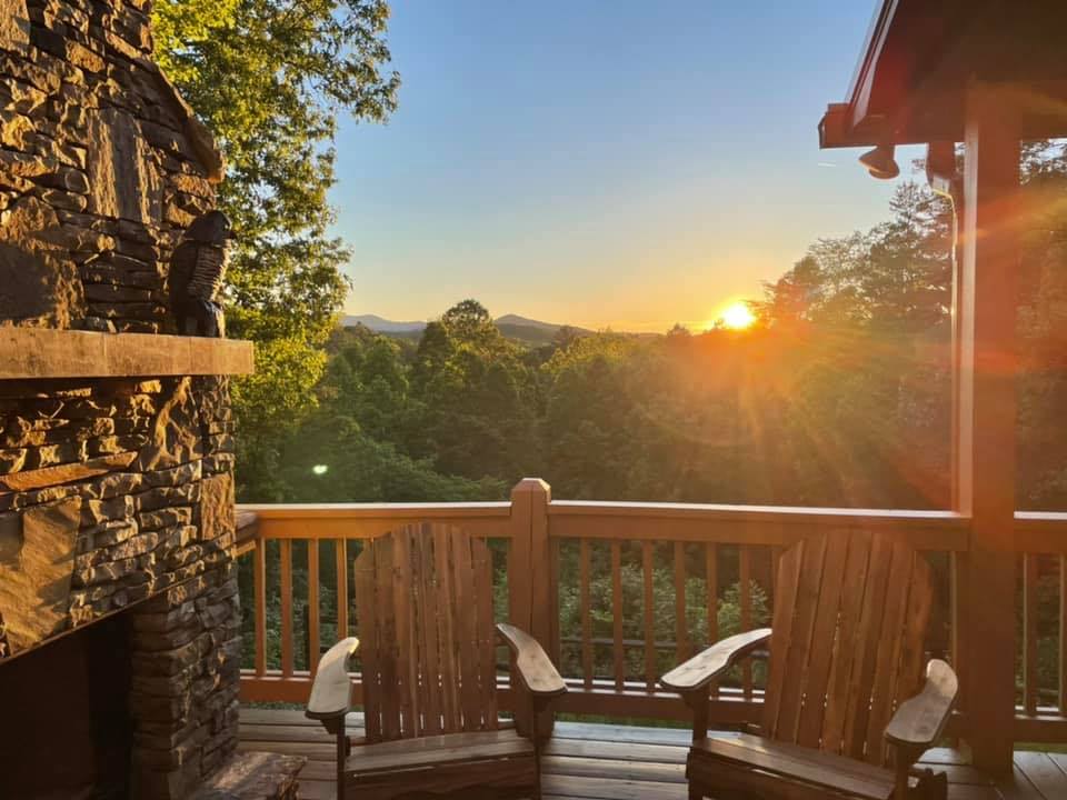 A view of a sunset in the mountains from a large balcony